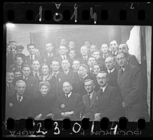 Large group portrait of well dressed men and women [probably members of the Judenrat, the Jewish Council]