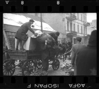 Men unloading goods from a wagon