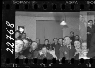 Residents sitting around a table at a reception in the ghetto