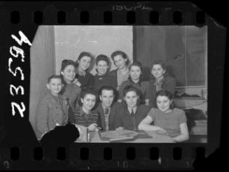 Group portrait of women with man and child around a table