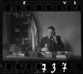 Administrator sitting at a desk with a telephone