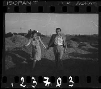 Couple walking among hay stacks