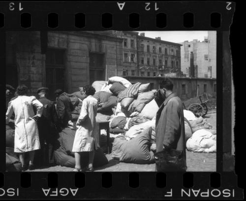 Mendel Grossman photographing residents sorting through the belongings of deported victims