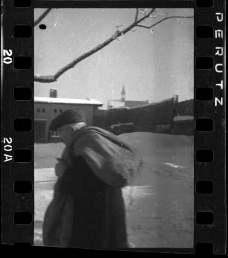 Man walking in winter with a parcel over his shoulder
