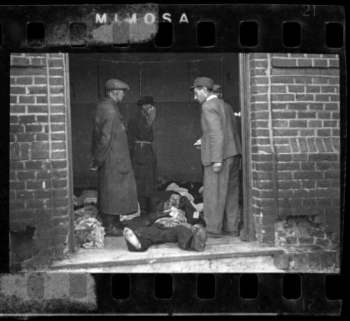 Ghetto officials standing among bodies in the morgue
