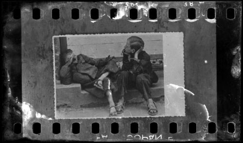 Two young boys sitting on the street