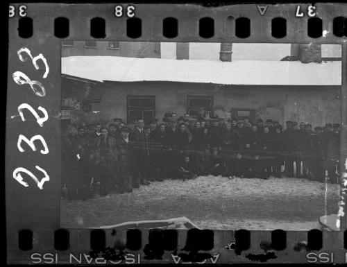 Large group of men and women workers and administrators of the Transport Department standing in the ghetto in winter