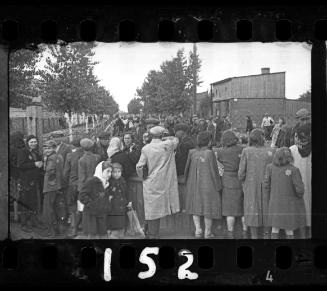 Ghetto residents talking through the fence of the central prison prior to deportation
