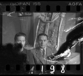 Administrators of the Holzwollefabrik workshop ("ressort") beside a commemorative display, with a portrait of Mordechai Chaim Rumkowski