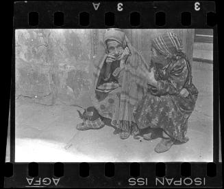 Two elderly women sitting on the street