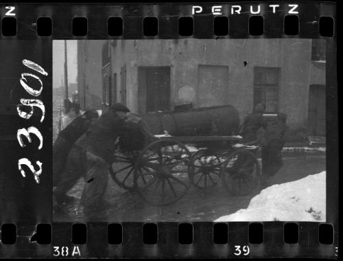 Fecal workers hauling a sewage collecting tank mounted on a wagon through the ghetto
