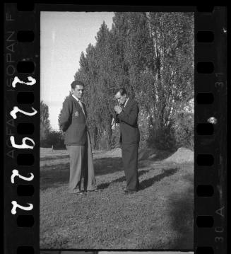 Two male ghetto residents, one lighting a cigarette