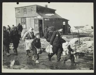 Boy walking to deportation in a group, wearing cap, satchel and backpack