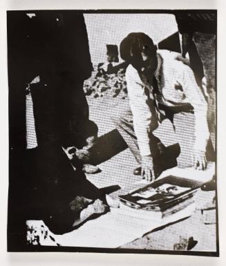 Henryk Ross and unknown man looking at photographs
