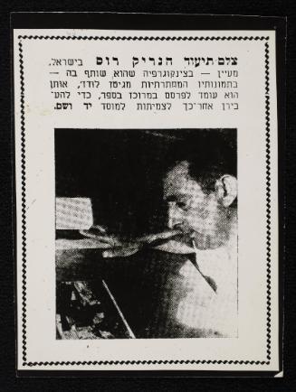 Henryk Ross looking at 'Ghetto Lodz' book