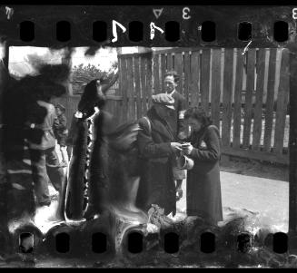 Man and woman conferring on the steet [probably prior to deportation]
