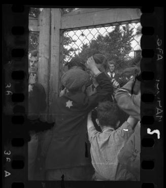 Children talking through fence of central prison on Czarnecki Street prior to deportation