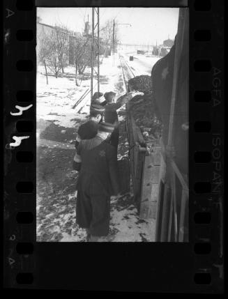 Residents collecting coal from a train car, overseen by ghetto police