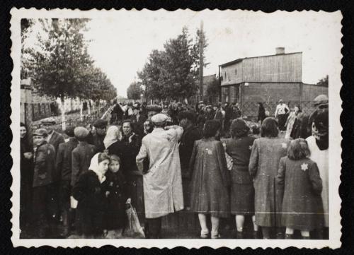 Row of residents talking through fence of central prison prior to deportation