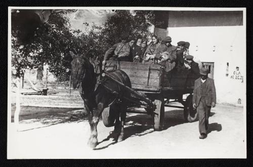 Man walking alongside horse-drawn deportation wagon carrying residents being deported from the ghetto