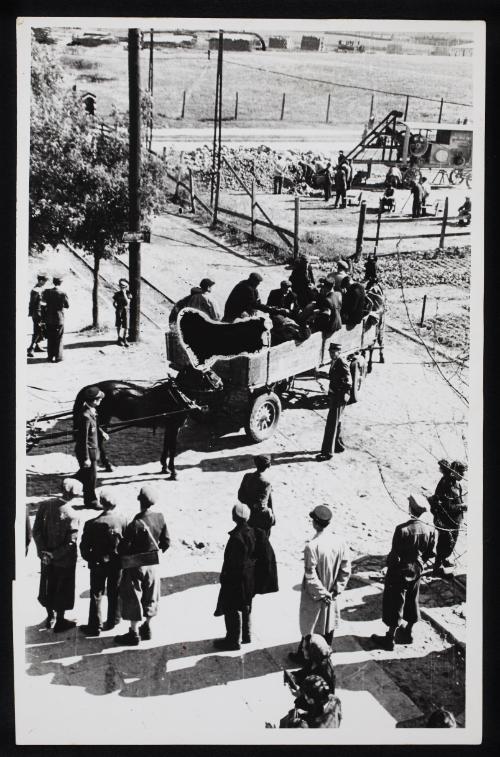 Ghetto police watching workers in horse-drawn wagon going to labour site