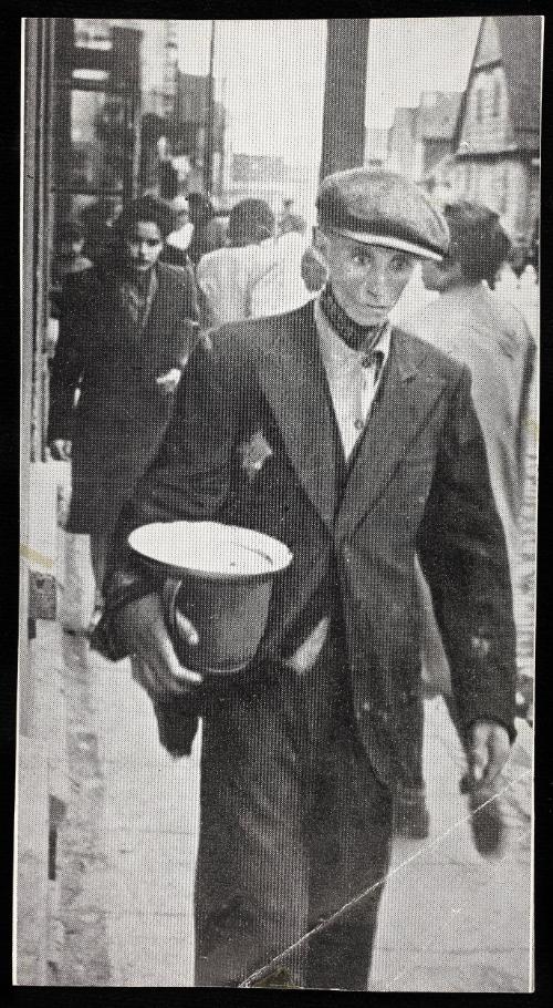 Hungry man walking on street with pail and empty plate