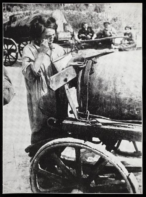 Female fecal worker standing and eating from pail