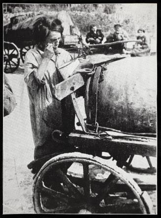 Female fecal worker standing and eating from pail