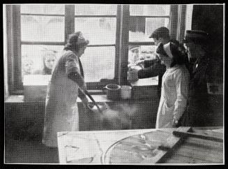 Woman cook ladling soup, at window to residents
