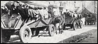 Three horse-drawn deportation wagons on the road