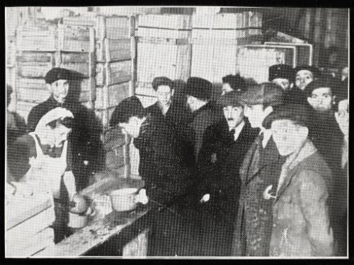 Cook ladling soup into pails for residents