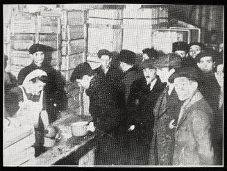 Cook ladling soup into pails for residents
