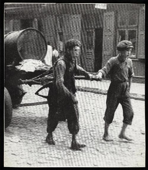 Two boys pulling fecal cart, barefoot