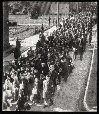 Throng of deportation turning at street corner (looking towards camera, from above)