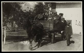 Man walking alongside horse-drawn labour wagon