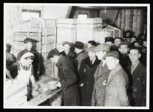 Cook ladling soup into pails for residents