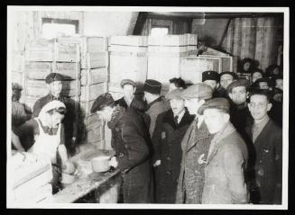 Cook ladling soup into pails for residents