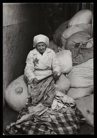 Elderly woman sorting the belongings of deported residents