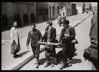 Three boys pulling cart along street