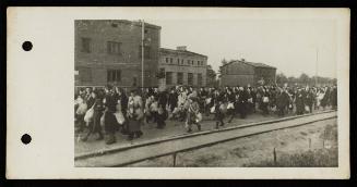 Mass deportation walking alongside train tracks