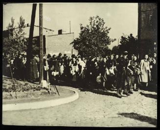 Mass deportation led by ghetto officials approaching corner