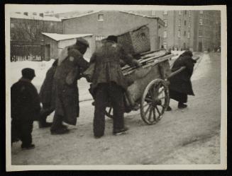 Ghetto residents hauling goods on cart
