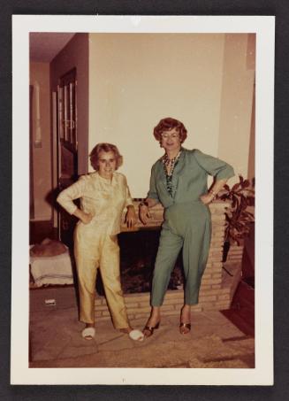 [Virginia Prince and Doreen standing by the fireplace, location unknown]
