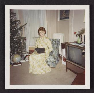 [Crossdresser sitting by the Christmas tree, location unknown]
