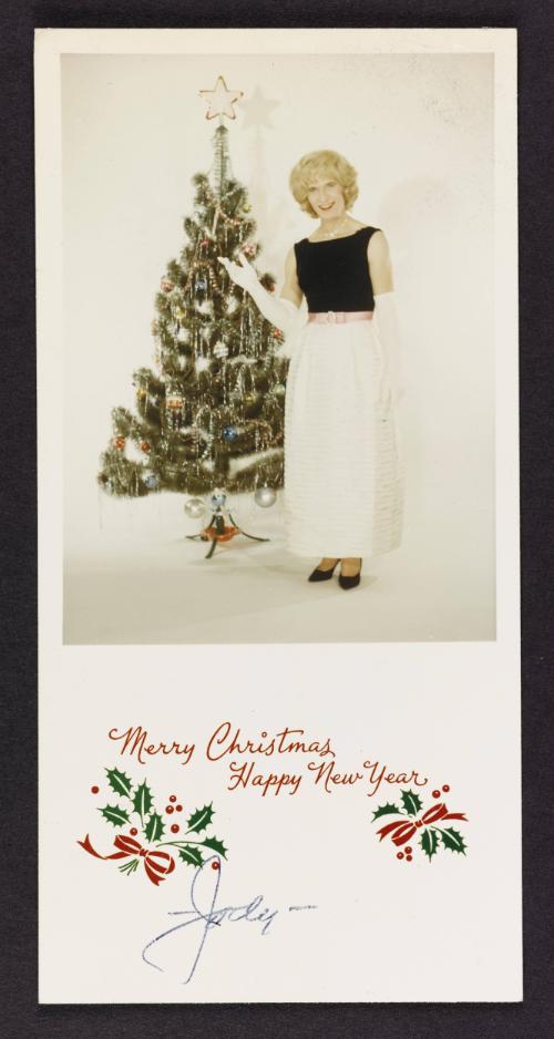 [Christmas card, Jody beside a Christmas tree, photo studio]
