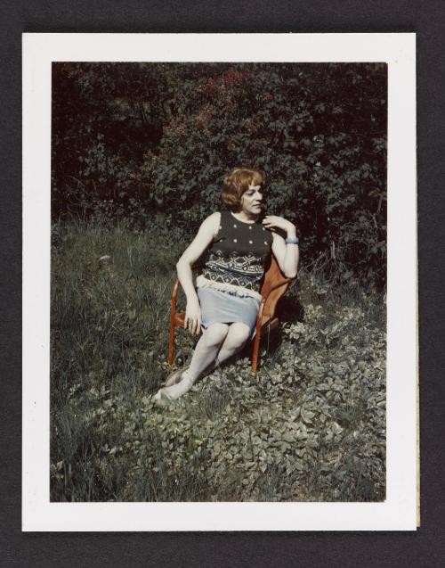 [Susanna sitting on a red chair in the grass, Casa Susanna, Hunter, NY]
