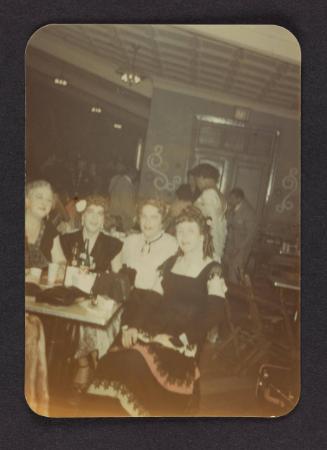 [Group dressed in period costume at a bar, location unknown]
