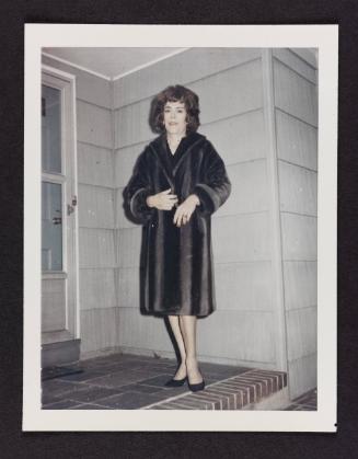 [Kathey on the steps in a fur coat, location unknown]
