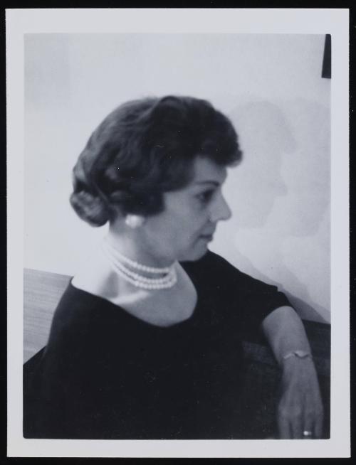 [Anita wearing pearls, posing in profile, location unknown]
