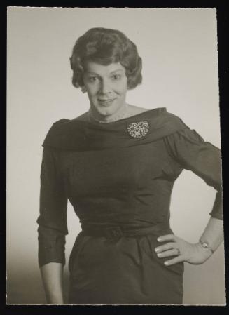 [Anita wearing pearls, posing in profile, location unknown]
